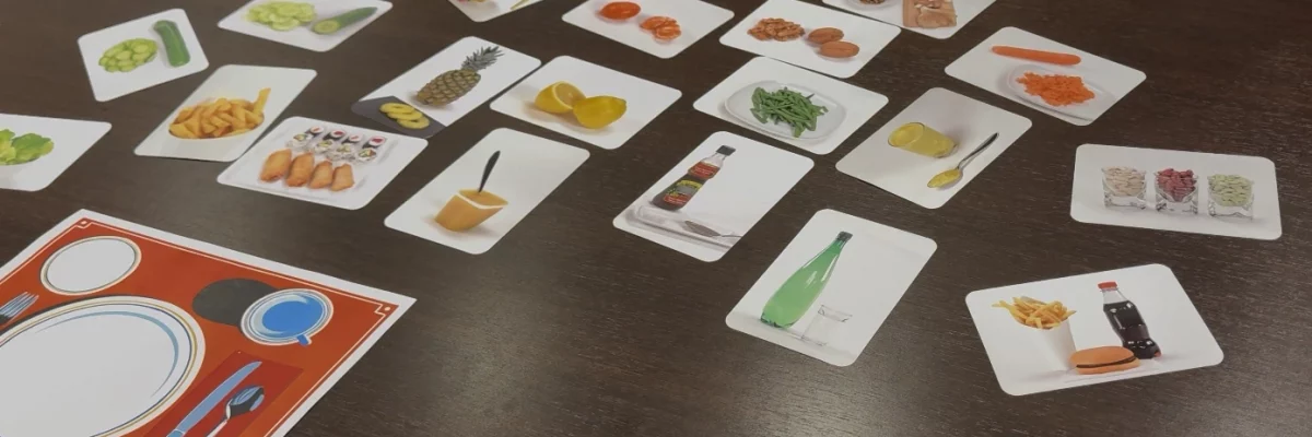 Cartes représentant différents aliments disposées sur une table pour un exercice de composition de repas